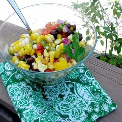 Summer Corn Salad in glass bowl with a serving spoon in it