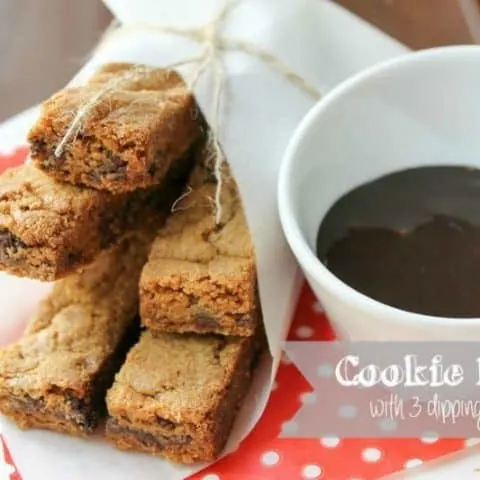 Cookie Fries wrapped with white paper and a bowl of dipping sauce on a red polka dot napkin