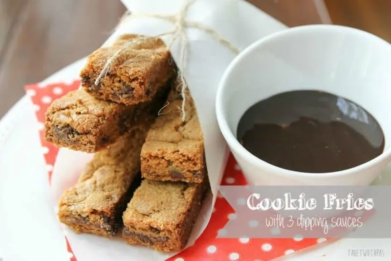 Cookie Fries wrapped with white paper and a bowl of dipping sauce on a red polka dot napkin