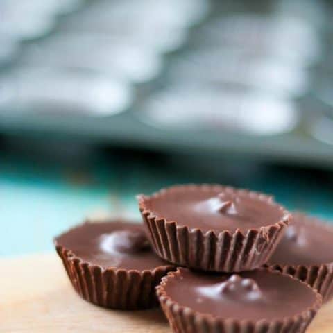 Side view of dark chocolate peanut butter cups on a cutting board