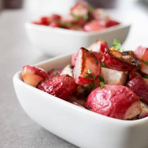 Side view of Crispy Garlic Radishes in a white bowl