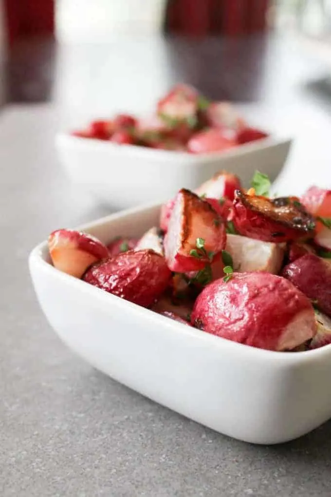 Side view of Crispy Garlic Radishes in a white bowl