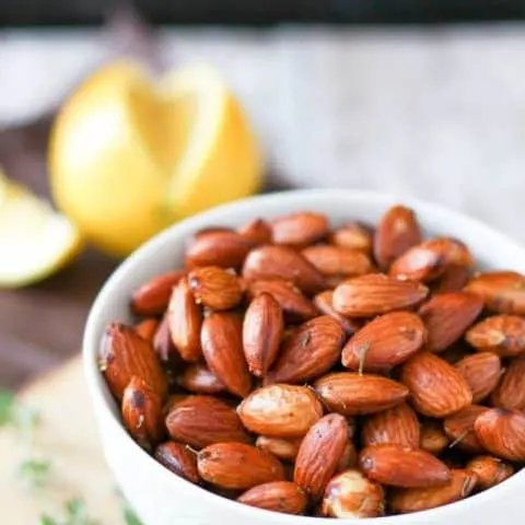 Close up of almonds with lemon thyme in a bowl