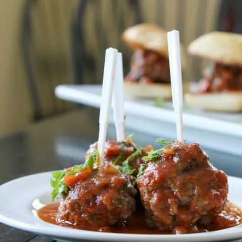 Mediterranean Lamb Meatballs with cocktail forks in them on a white plate