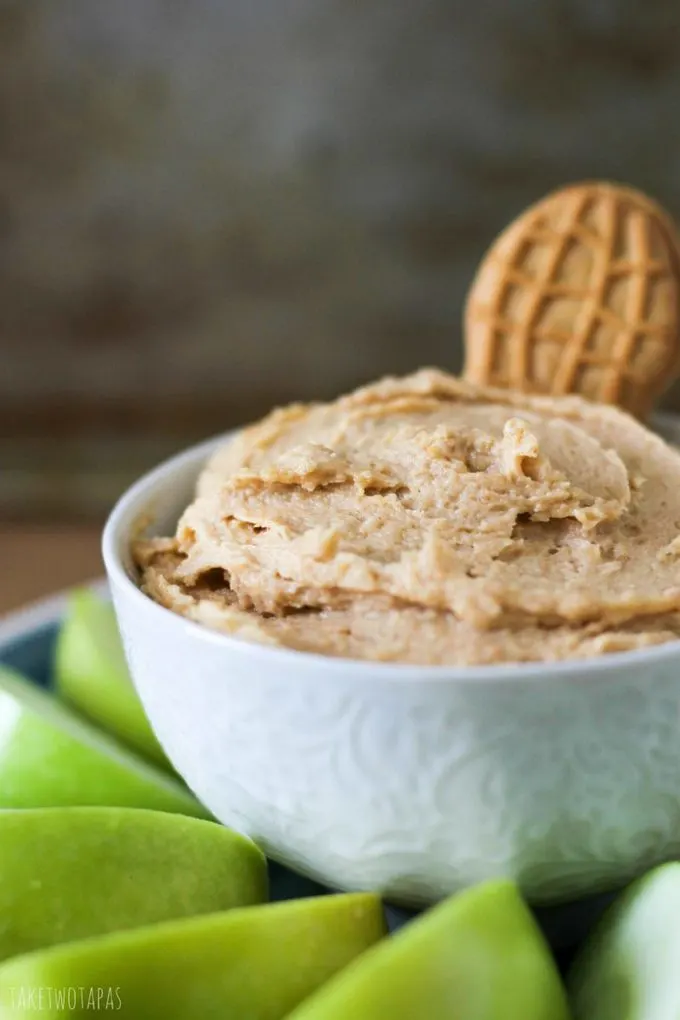 Nutter Butter Dip with Nutter butter cookie in it with apples surrounding the bowl
