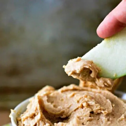 Nutter Butter dip with a hand dipping an apple in it
