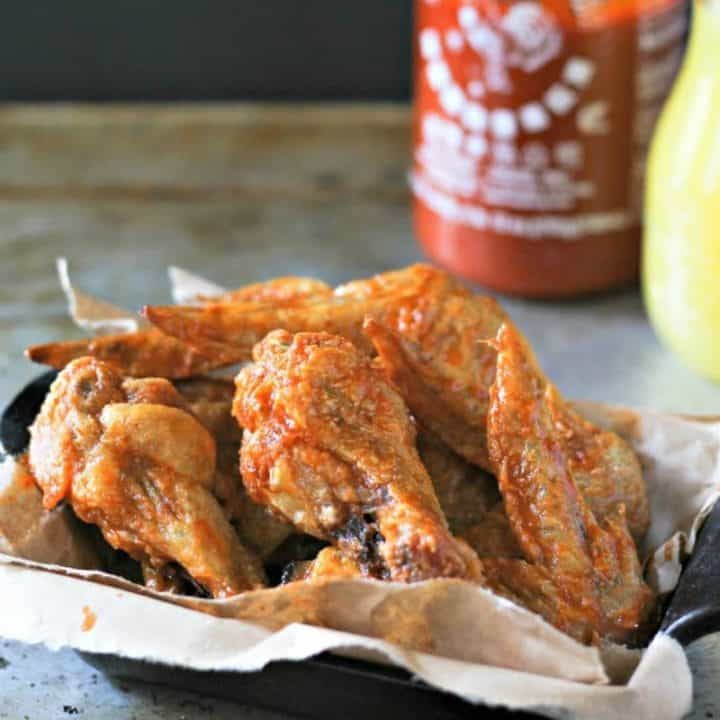 close up of Spicy Sriracha Pineapple Chicken Wing in a black serving dish