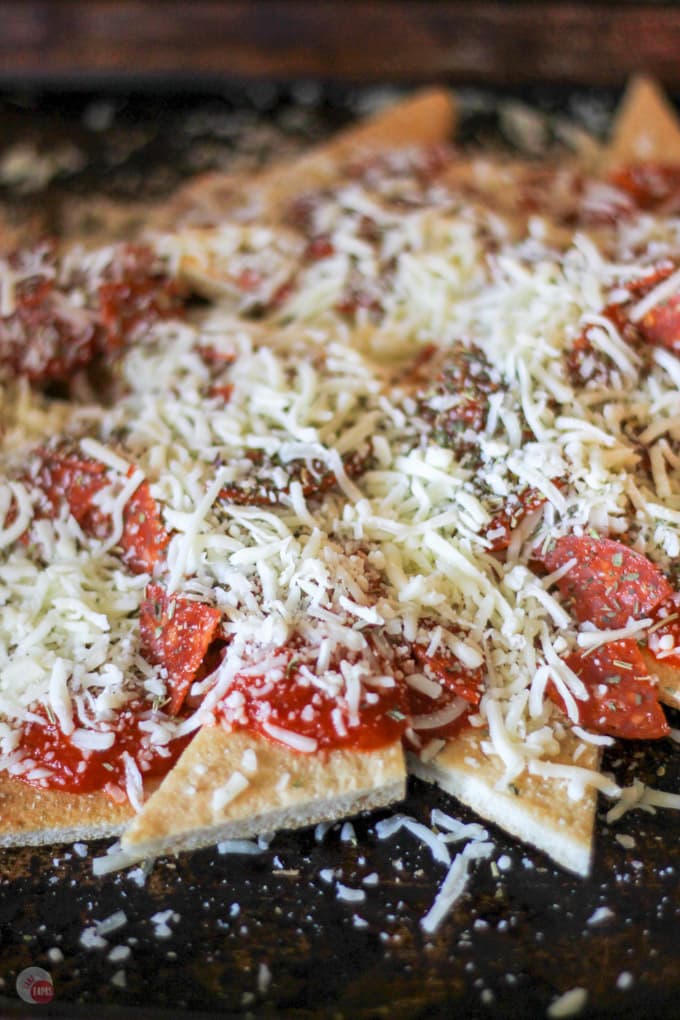 close up of pizza nachos on a sheet pan