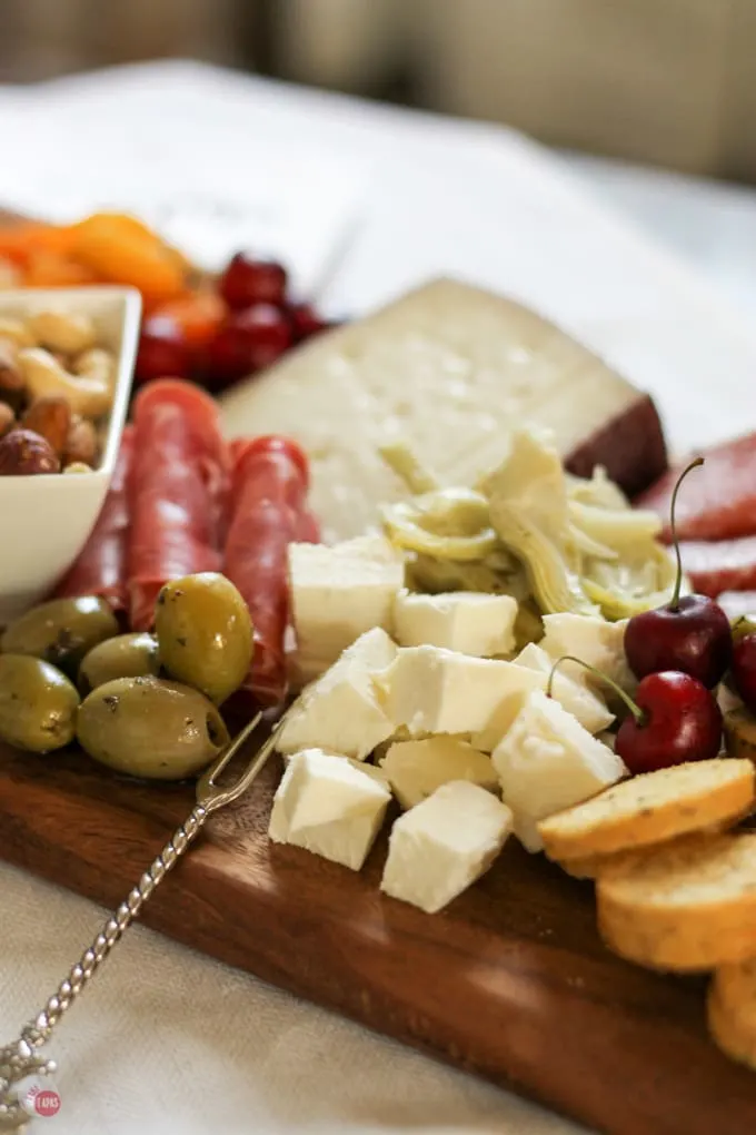 Up close of cheese, olives and meats on the summer tapas cheese board