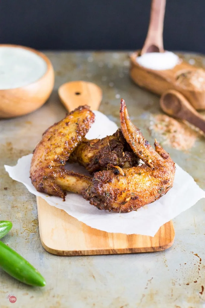 Baked crispy chicken wings dusted with Jamaican Jerk Seasoning on a cutting board