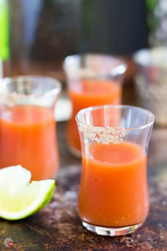 side view of Bloody Mary Shots on a wood surface