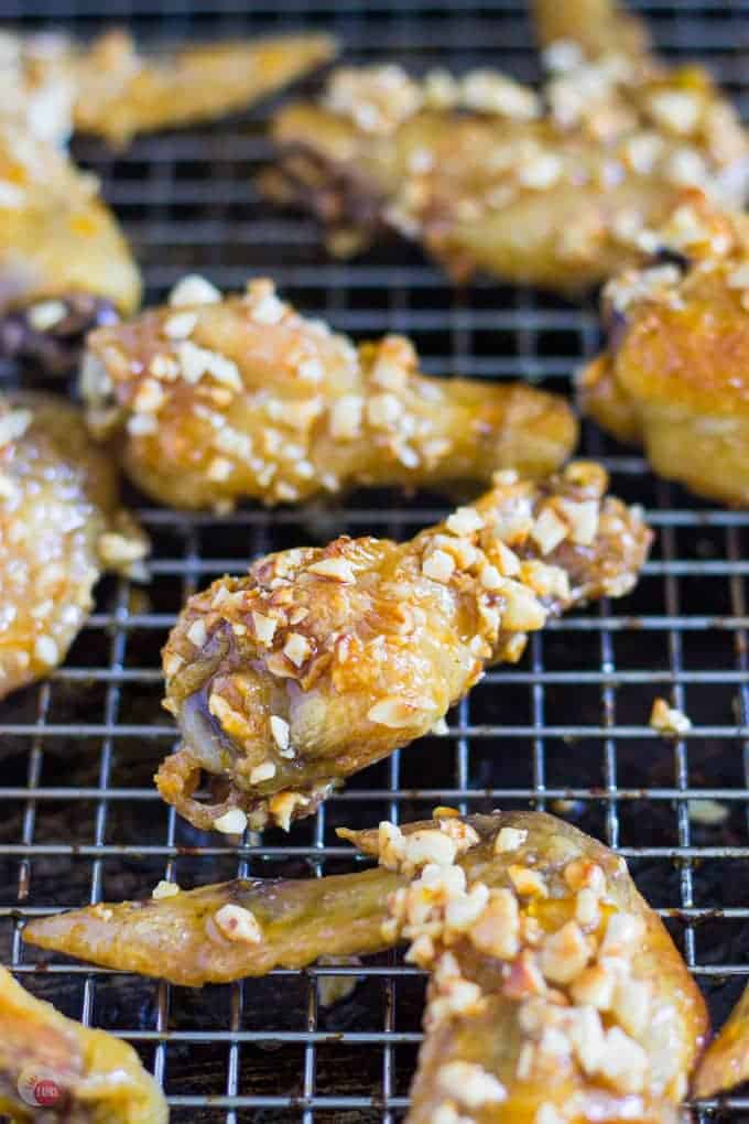 If you love Orange Cashew Chicken at your local Chinese restaurant, you can make it at home but as a chicken wing! Sticky orange glaze covering crispy baked chicken wings and rolled in roasted cashews for even more crunch! Orange Cashew Chicken Wings Recipe | Take Two Tapas | #Orange #Cashew #ChickenWings #ChineseTakeOut #ChineseFood #ChickenWingSauce #FingerFoods