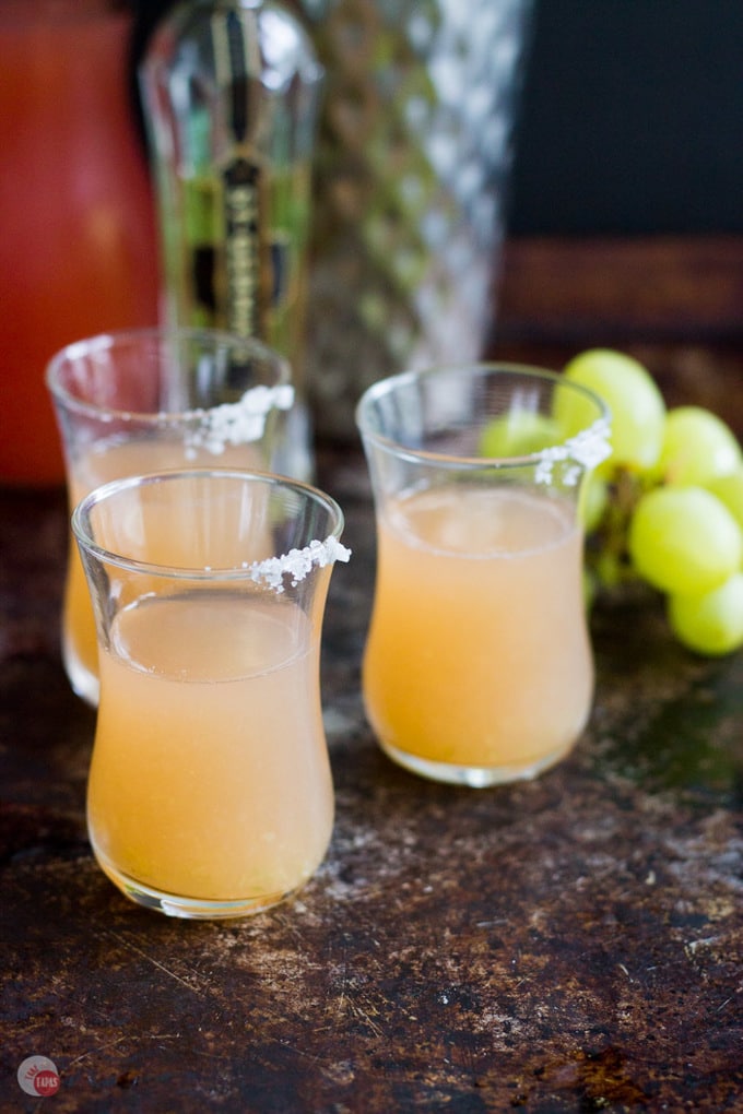 This tart and flavorful Salty Dog Shot will remind you of a salty dog cocktail but with the flavors of green grapes and much smaller! Green Grape Salty Dog Cocktail Shot Recipe | Take Two Tapas | #GreenGrapes #SaltyDog #CocktailShots #Vodka #PinkSalt #SaltyDogShot