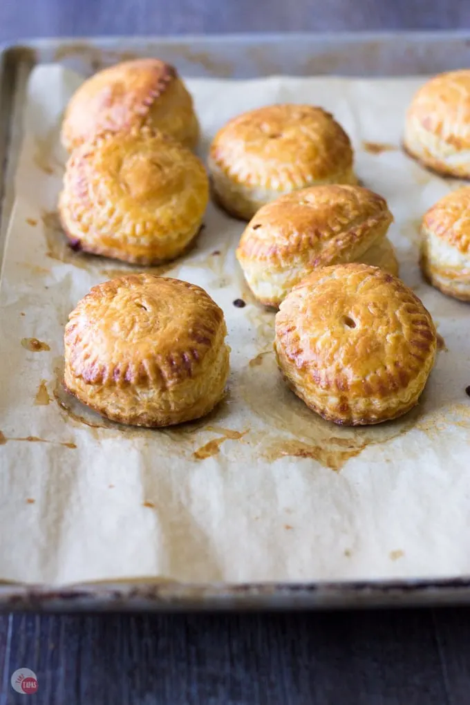 Smoked chicken roasted grape hand pies on a parchment lined sheet pan
