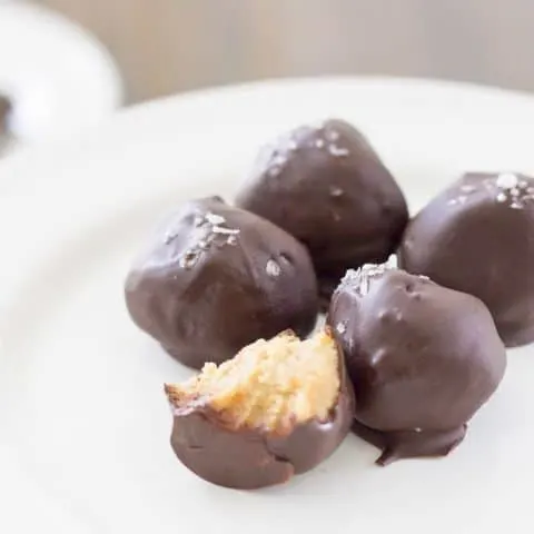 Truffles on a white plate. One with a bite out of it