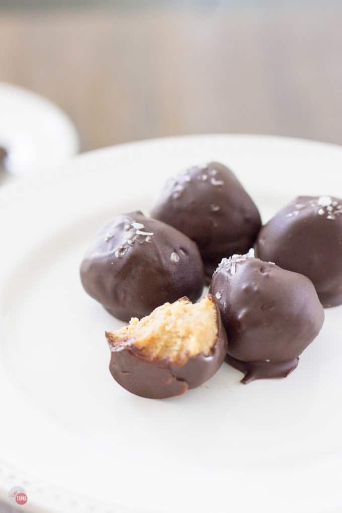 Truffles on a white plate. One with a bite out of it