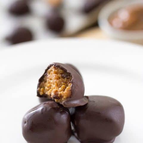 Side view of Dulce de Leche fireball truffles on a white plate.