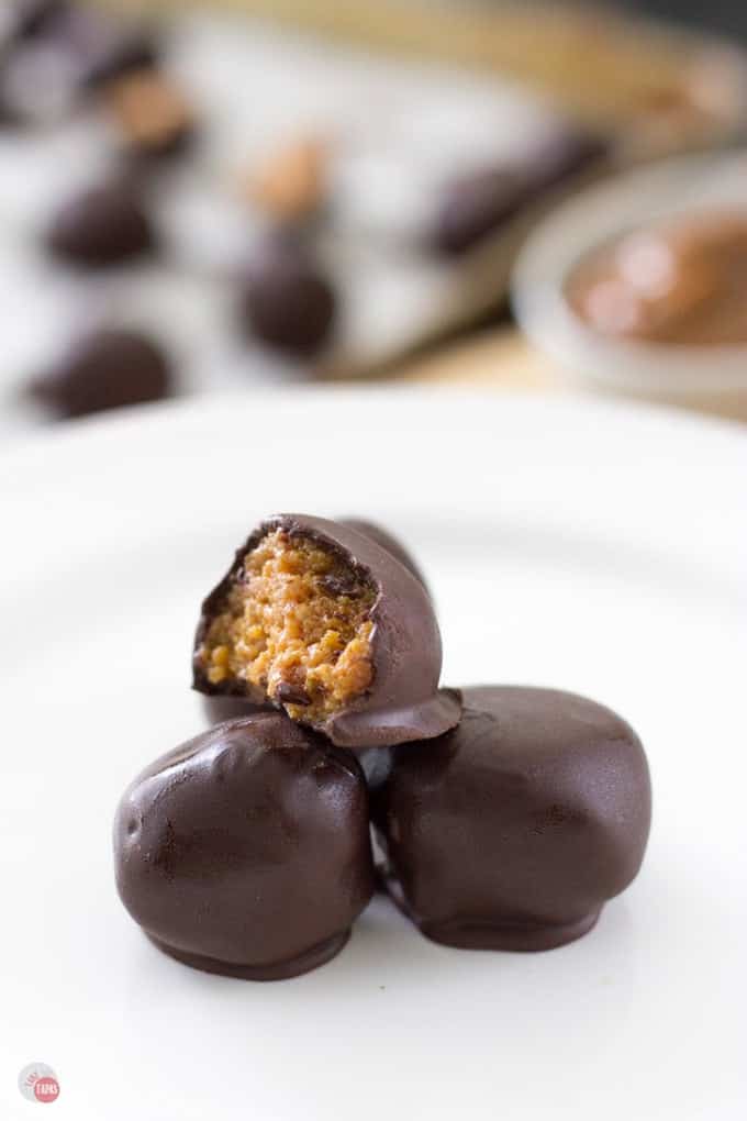 Side view of Dulce de Leche fireball truffles on a white plate.