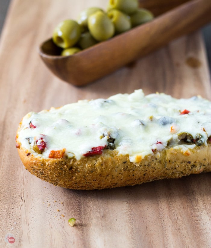 Toasty French Bread is topped with my New Orleans Olive Salad and covered with cheese.