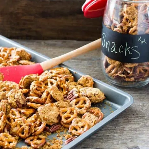 Crack Pretzels with Crispy Caramel and Pecans on a sheet pan and in a jar