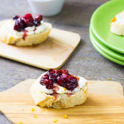 roasted cranberry ricotta crostini on a mini cutting board