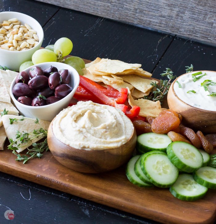 kantenhoek van hummus in een kom met gesneden paprika en een schaaltje olijven