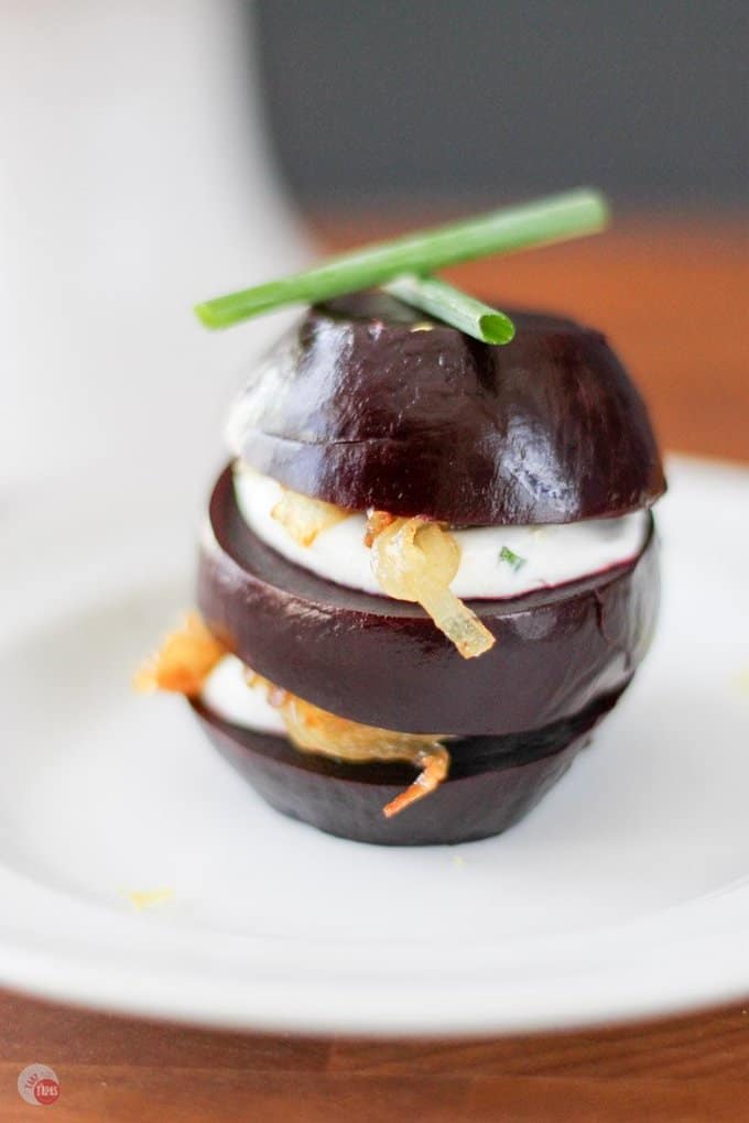 Close up of a pickled beet napoleon on a white plate.