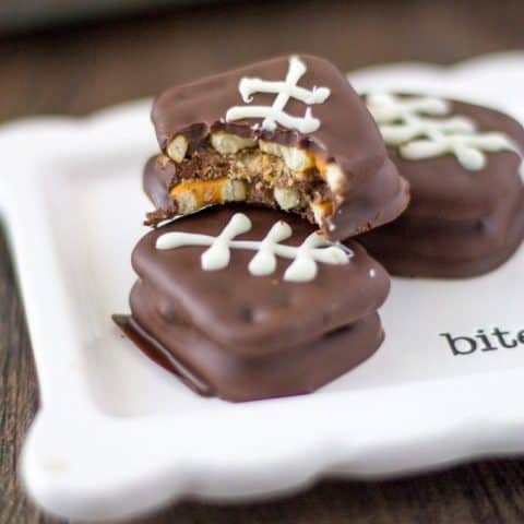 Big Game Reese's Pretzel Football Cookies |on a white square plate. One has a bite out of it.
