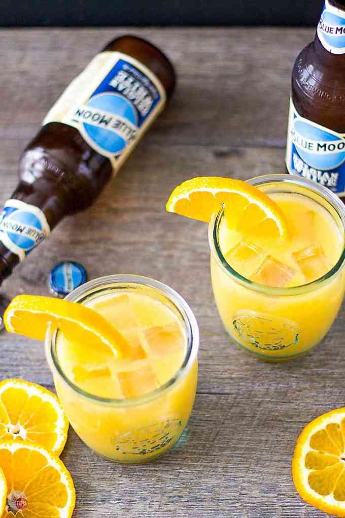 orange shandy cocktails with ice and beer bottles