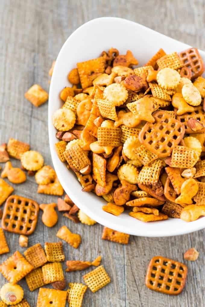 A classic snack mix is spiced up with Sriracha and red pepper flakes. The combination of Chex cereal, cheesy fish and square crackers, pretzels, and oyster crackers is perfect for snacking while you are cheering on your favorite sports team in the big game! Snack Mix with Spicy Sriracha Recipe | Take Two Tapas