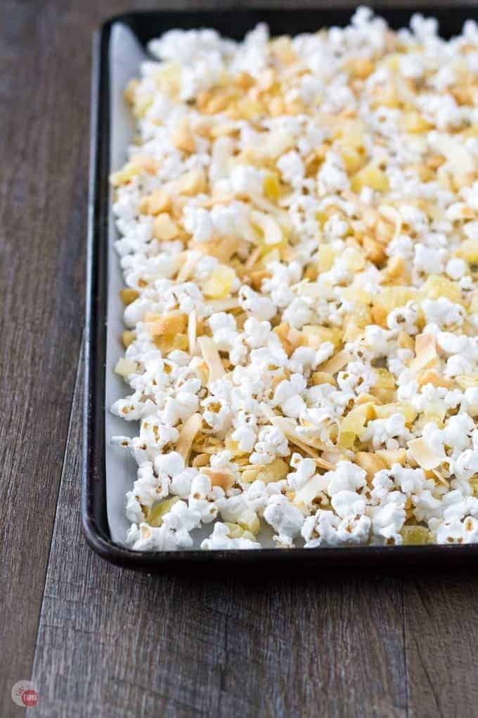 Popcorn mixture spread out on a sheet pan.