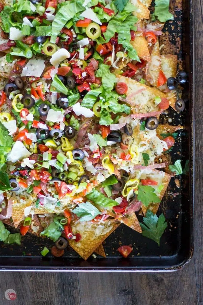 Overhead of Italian sheet pan nachos on a wood surface