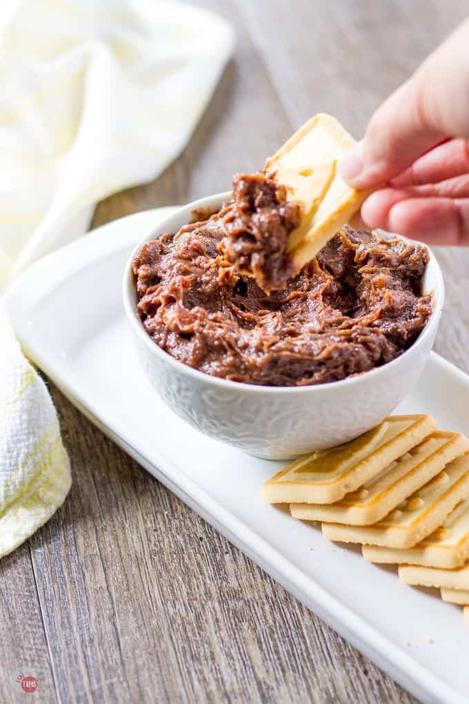 Dipping a cookie in to the Kentucky Derby Pie Dip with Pecans