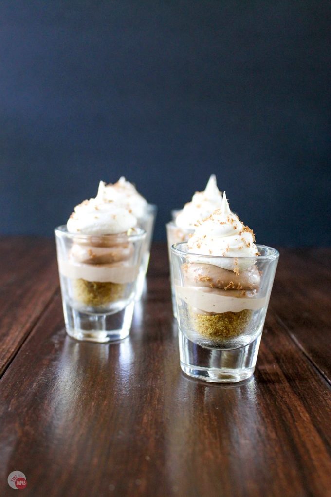 Side view of Nutella salted caramel cheesecake shooters on a table