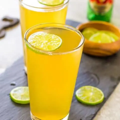 Two 3 Ingredient Margarita Beer Shandy Cocktails on a wood plank.