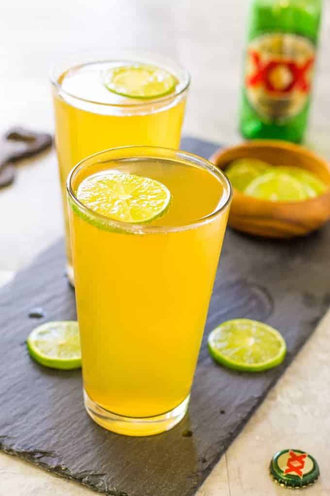 Two 3 Ingredient Margarita Beer Shandy Cocktails on a wood plank.