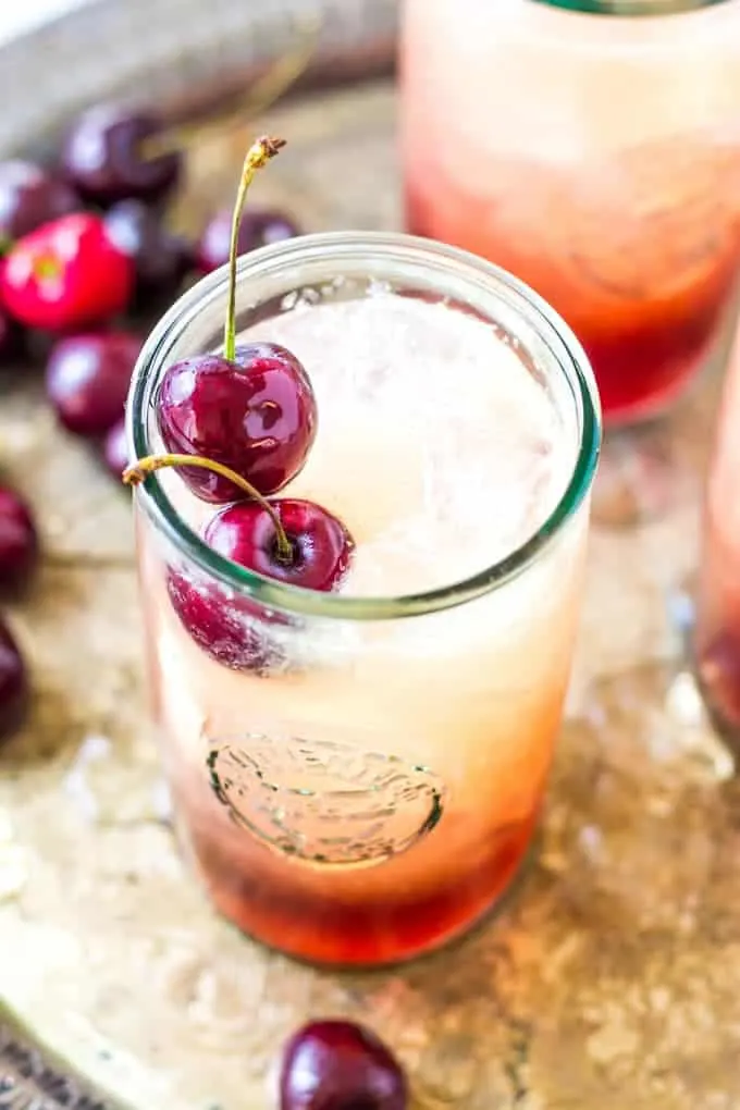 overhead of Cherry Amaretto Limeade Cocktail which is on a silver serving tray.