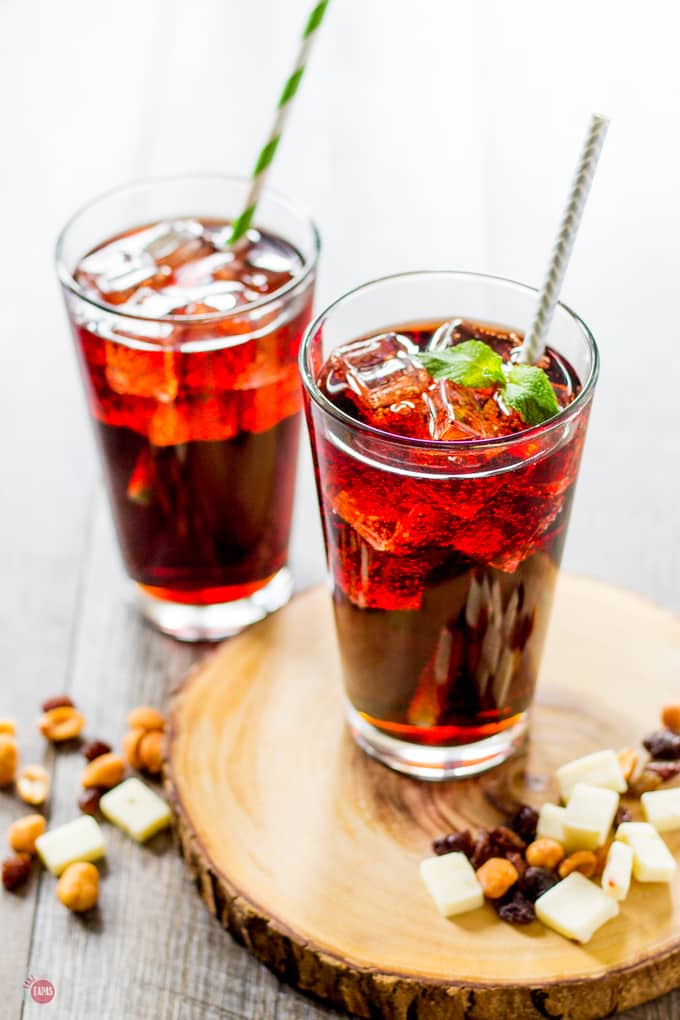 Kalimotxo Cocktail with mint garnish on a wood platter