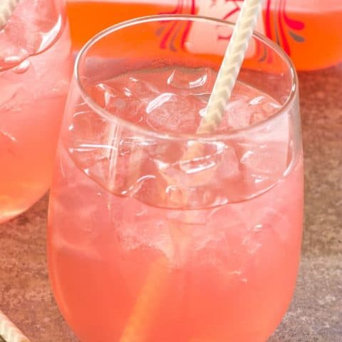 close up of Pink Passion Party Punch in a glass with a straw in it.