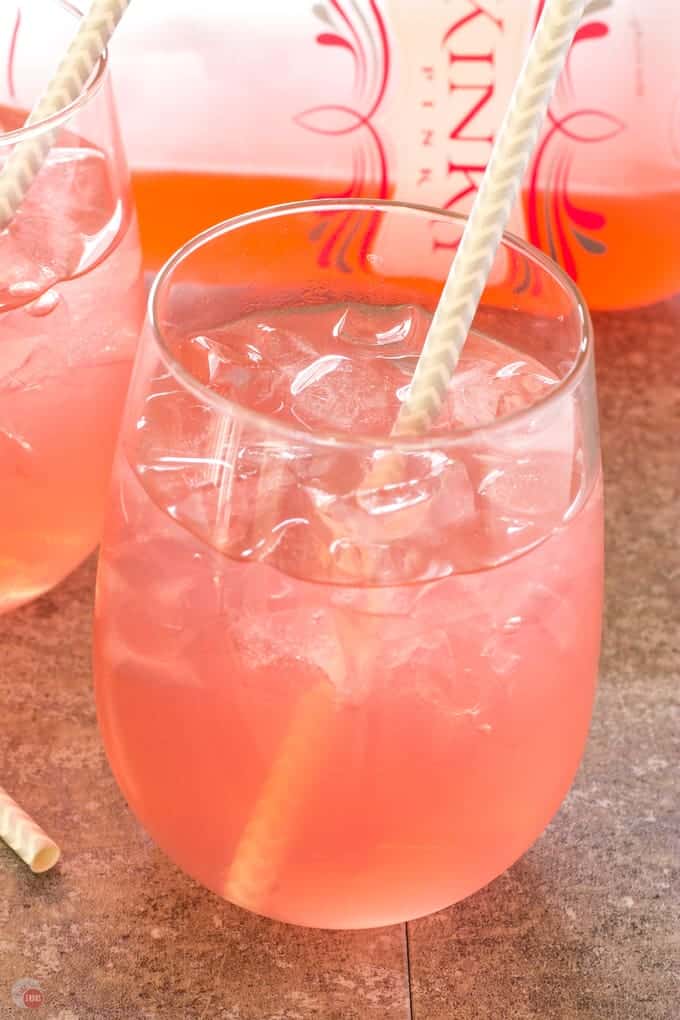 close up of Pink Passion Party Punch in a glass with a straw in it.