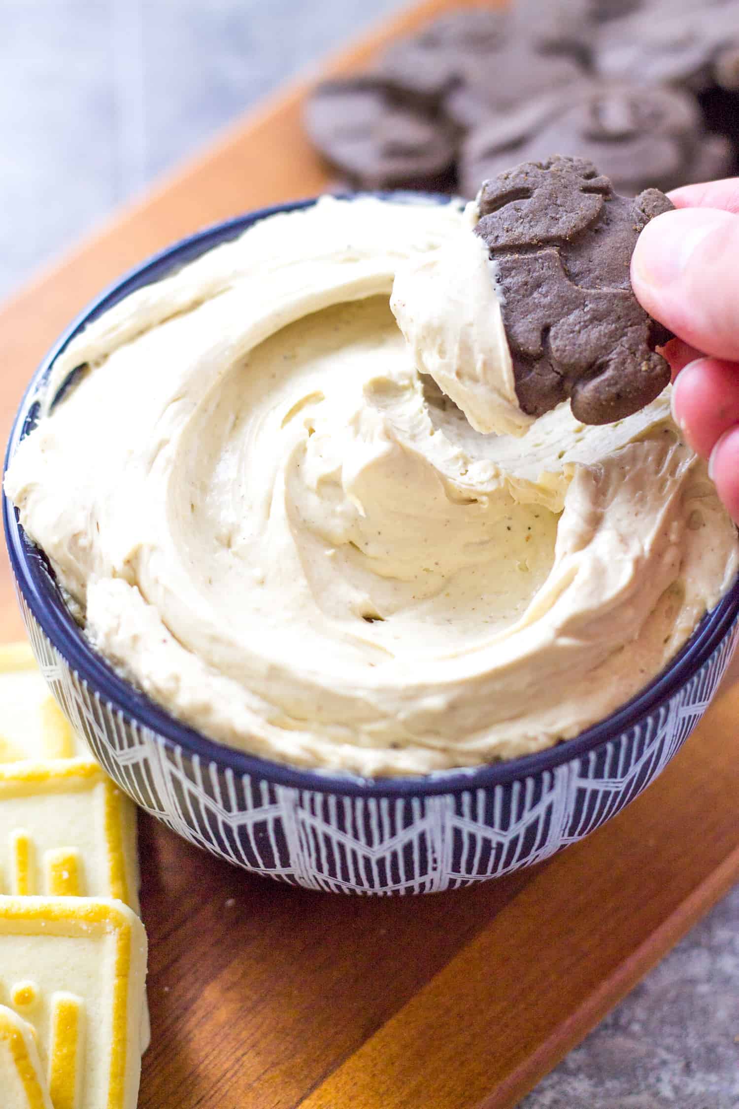 Close up of hand dipping cookie in to dip