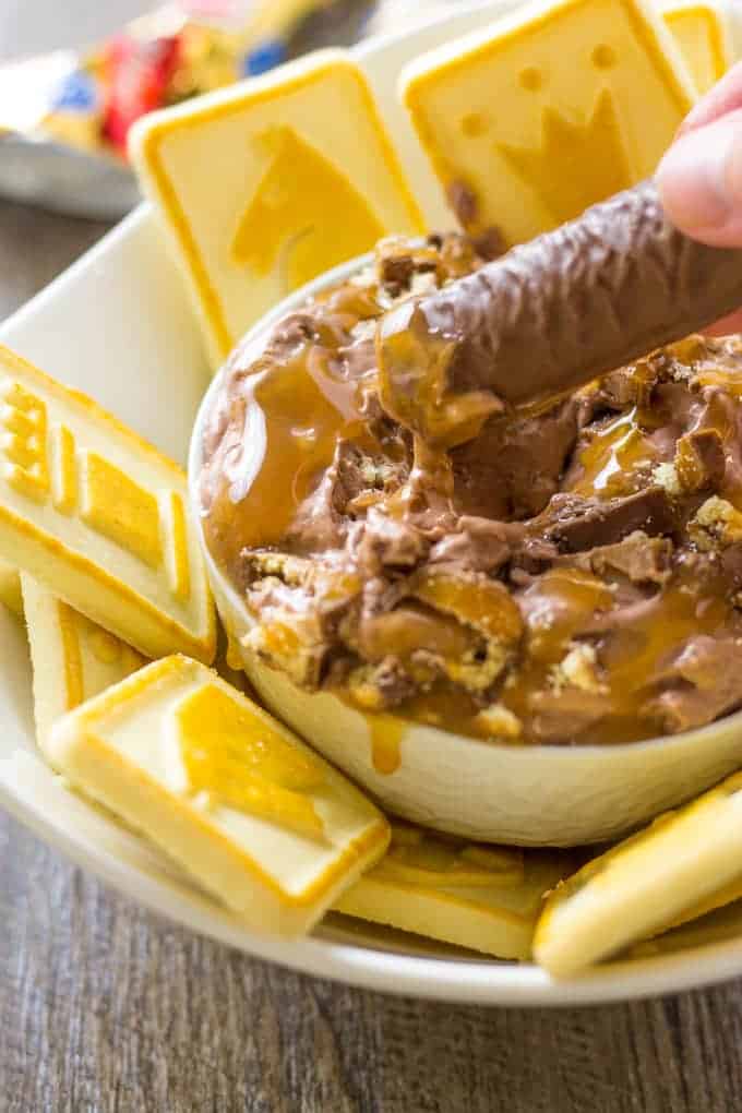 Dipping a twix candy bar in to the twix dip