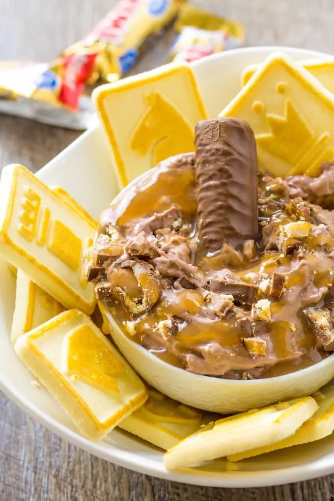 Chocolate Fudge Caramel Twix Dip surrounded by shortbread cookies in a bowl