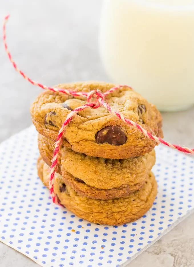 close up of stacked Cinnamon Chocolate Chip Cookies tied with a red and white string sitting on a polka dot napkin.