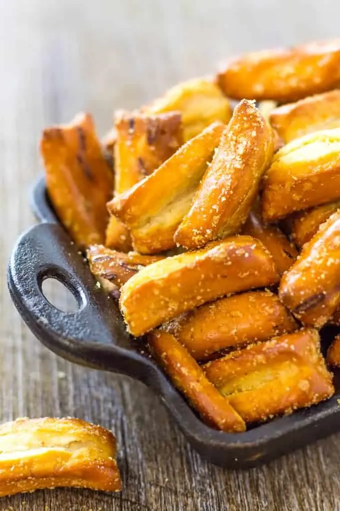 close up of Tangy French Onion Pretzel Nuggets in a cast iron platter on a wood table