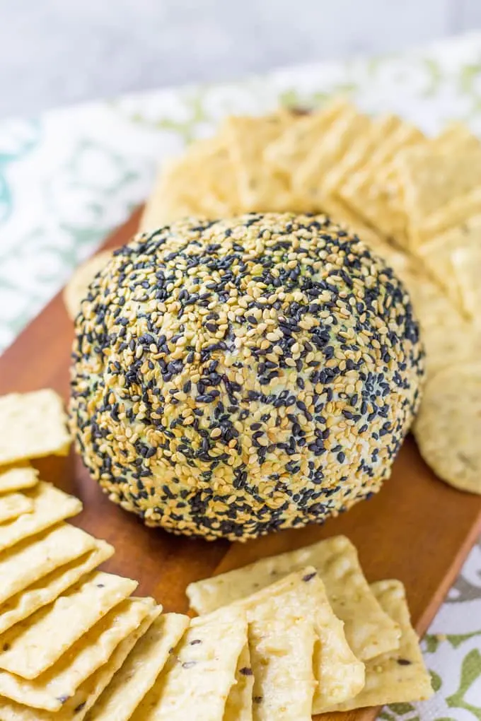 close up of Wasabi Ginger Cheese Ball and crackers on a cutting board