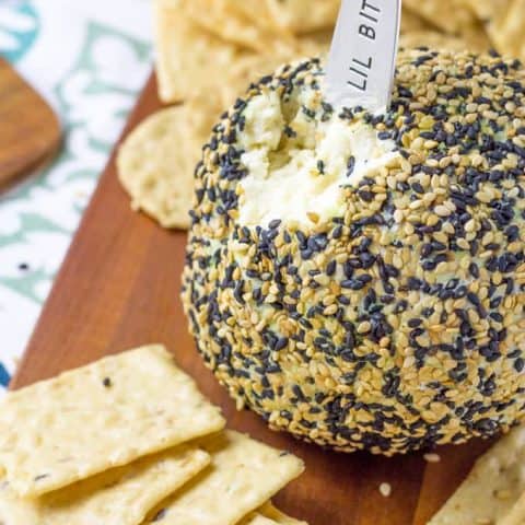 Wasabi Ginger Cheese Ball sitting on a cutting board surrounded by crackers
