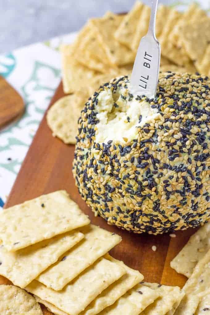Wasabi Ginger Cheese Ball sitting on a cutting board surrounded by crackers