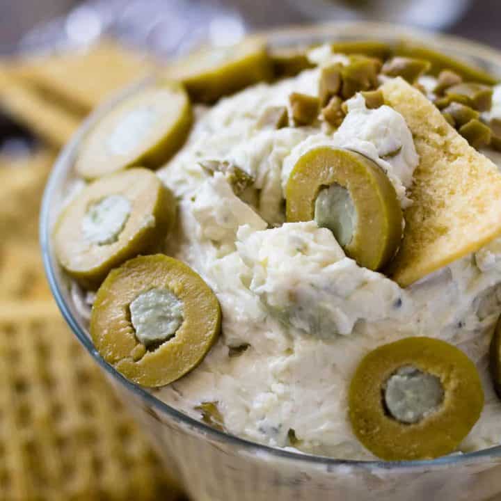 close up of dirty martini cheese ball with blue cheese stuffed olives in a martini glass