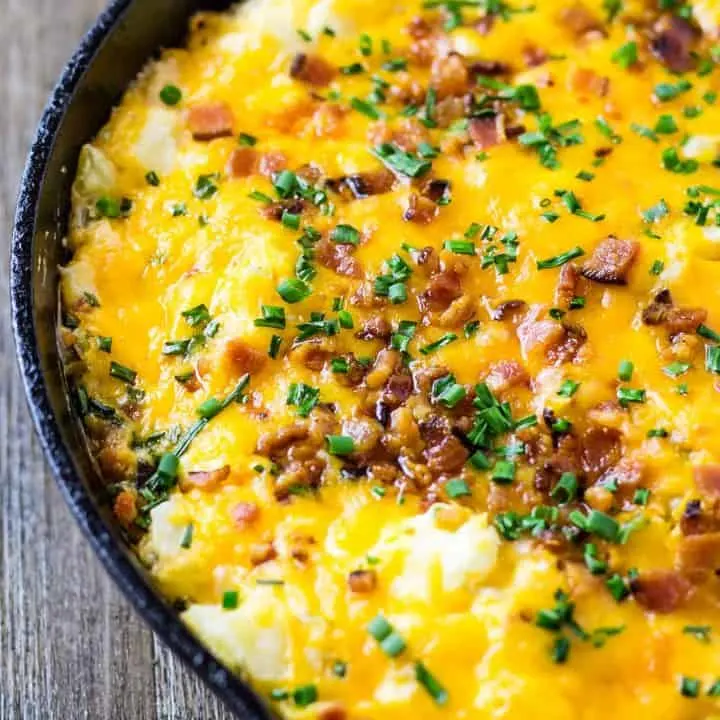 Loaded Potato Skin Dip all together in a skillet sitting on a wood table
